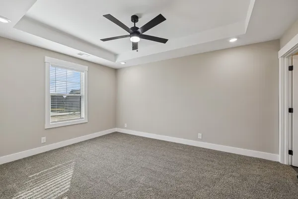 an empty room with a window and a fan