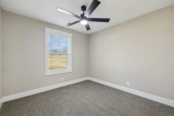 an empty room with a window and a fan