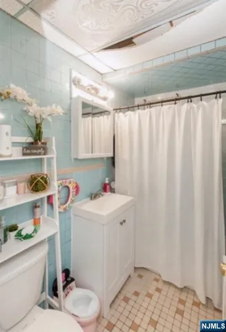 a bathroom with a sink a toilet and shower curtain