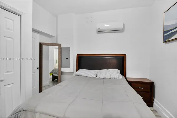 a bedroom with a bed and a painting on the wall