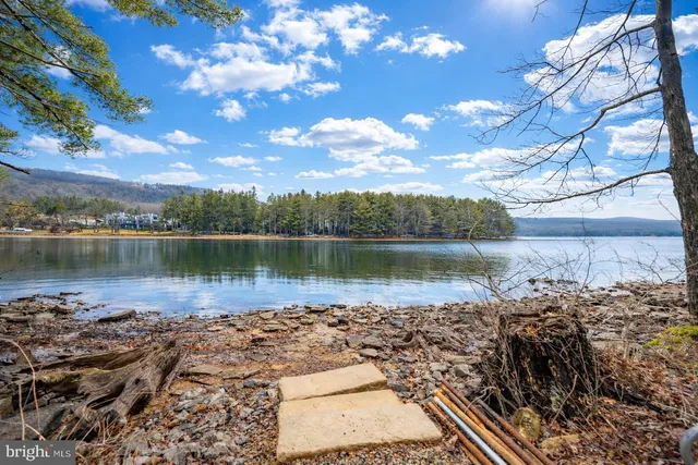 a dining room with wooden floor a chandelier a wooden table and chairs