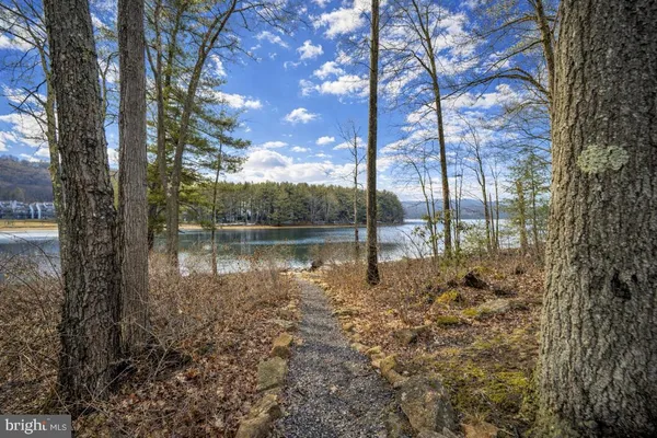 a dining room with wooden floor a chandelier a wooden table and chairs