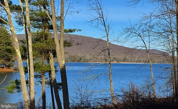 a dining room with wooden floor a glass table and chairs