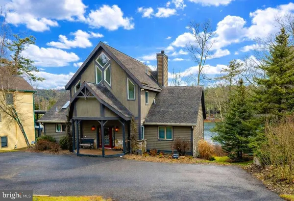 a view of a chairs and table in patio with a lake view