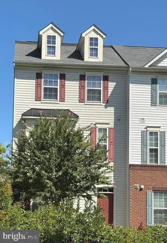 a kitchen with stainless steel appliances kitchen island granite countertop a refrigerator a stove and a wooden floors