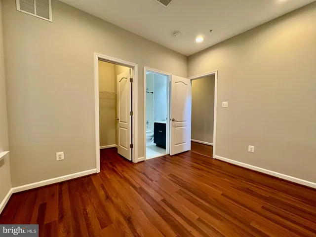 a bathroom with a bathtub shower sink vanity mirror and toilet