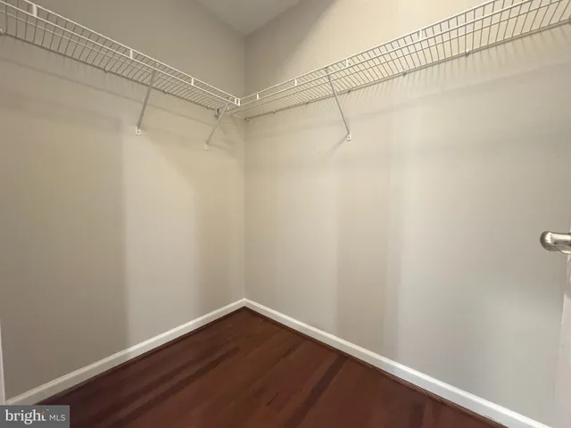 a kitchen with granite countertop a stove a sink dishwasher a refrigerator and wooden floor