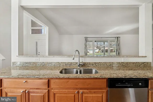 a kitchen with stainless steel appliances granite countertop a sink and cabinets with wooden floor