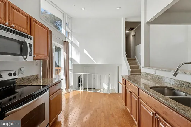 a kitchen with stainless steel appliances granite countertop a sink a stove and a refrigerator