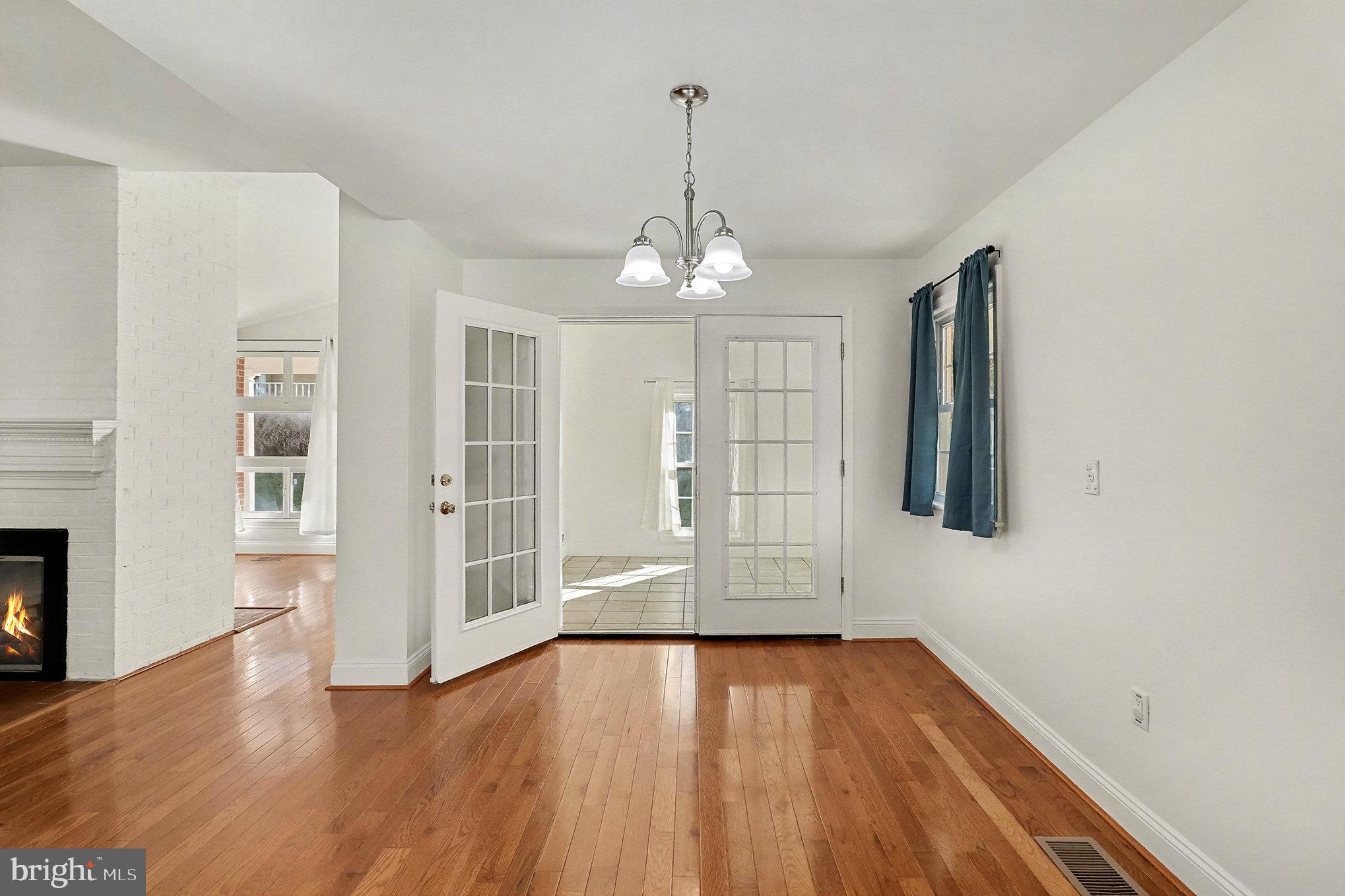 18316 Cabin Road Triangle, VA 22172 - Photo 16 of 42 an empty room with wooden floor chandelier and windows