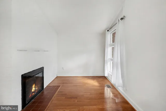 a view of a hallway with wooden floor and a fireplace