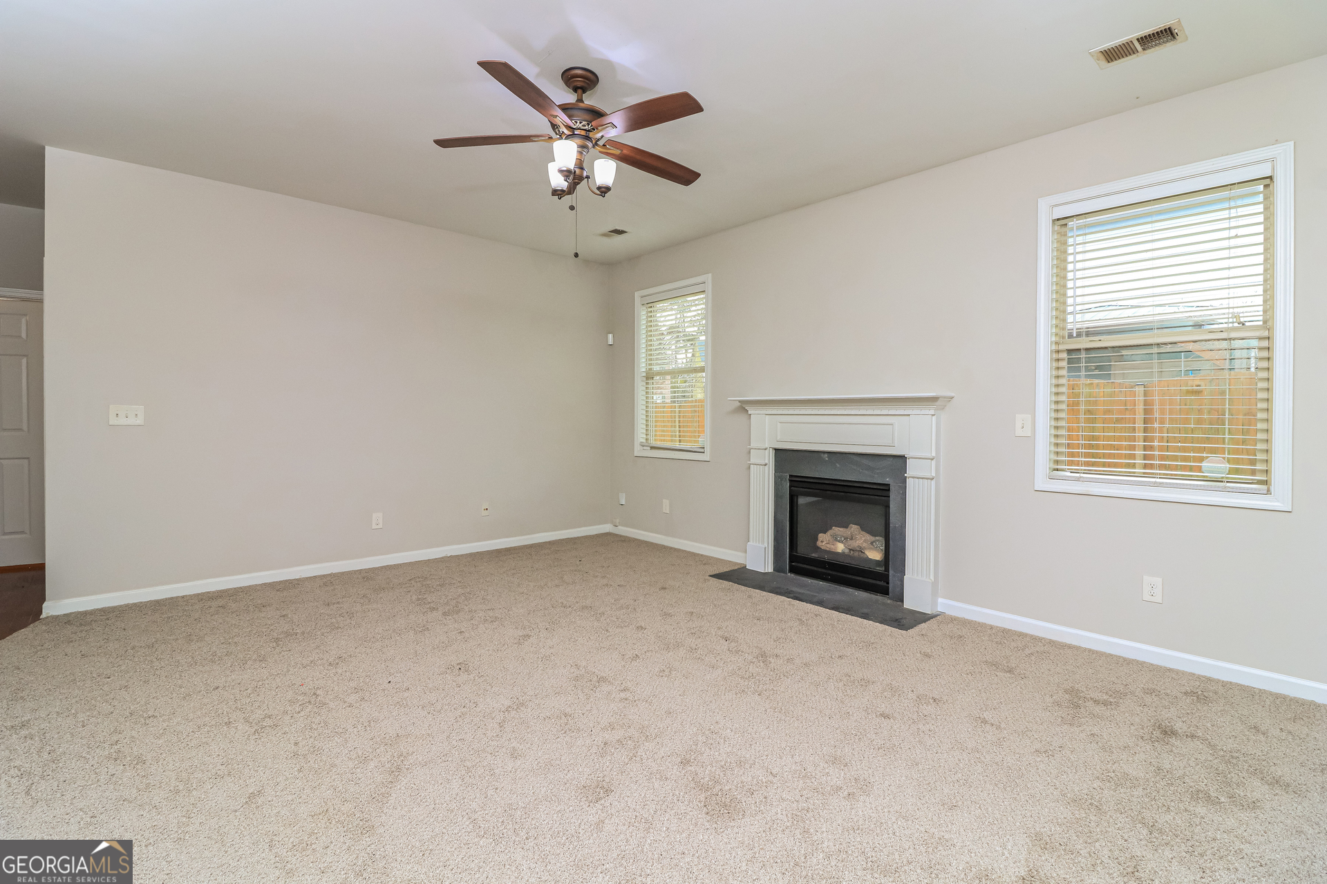 2570 Kolb Manor Circle Southwest Marietta, GA 30008 - Photo 5 of 22 a view of an empty room with chandelier fan and fire place