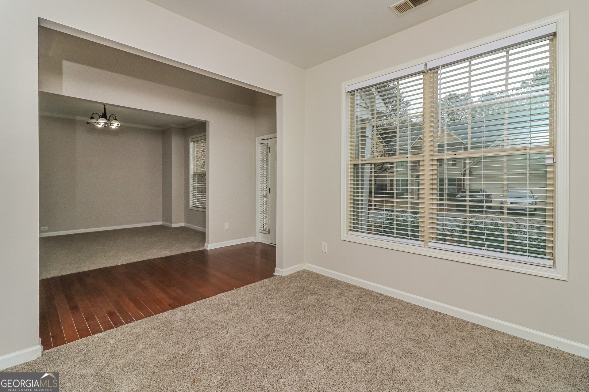 2570 Kolb Manor Circle Southwest Marietta, GA 30008 - Photo 7 of 22 a view of an empty room with wooden floor and a window