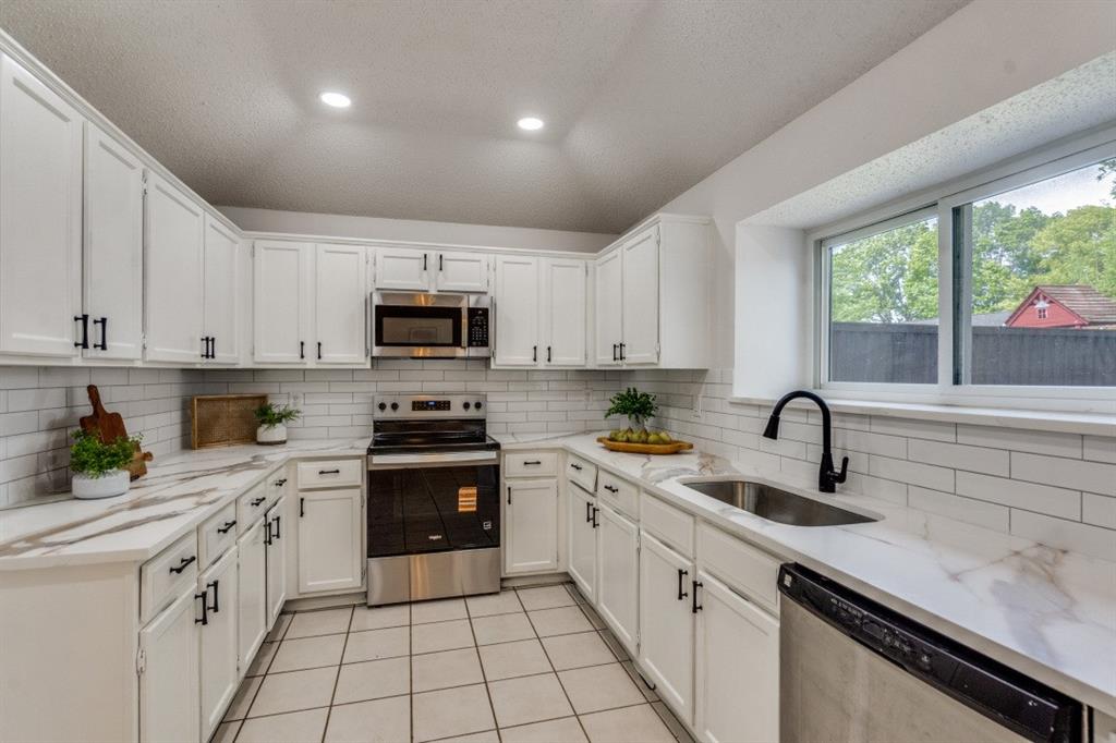 1509 Clover Drive Allen, TX 75002 - Photo 16 of 25 a kitchen with a sink stove top oven and cabinets