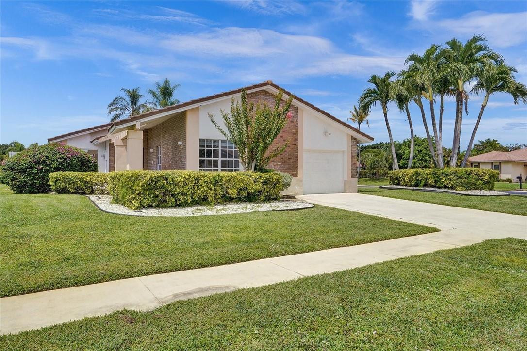 a view of a house with a yard and potted plants