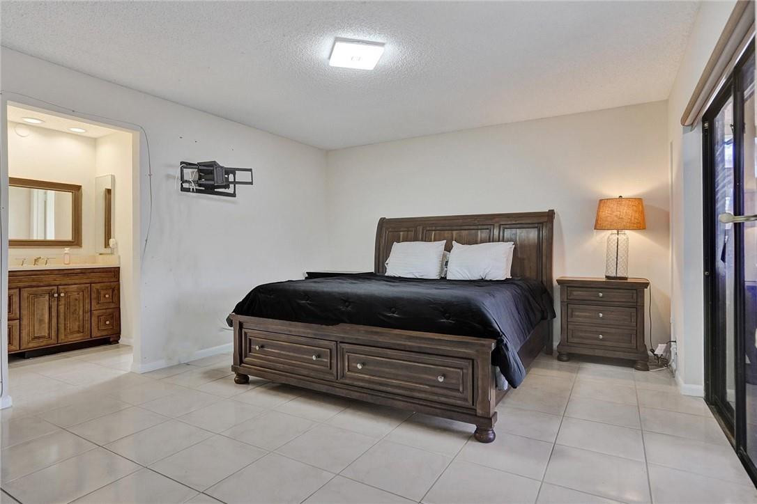 10066 Camelback Lane Boca Raton, FL 33498 - Photo 13 of 34 a bedroom with a bed and a cabinets