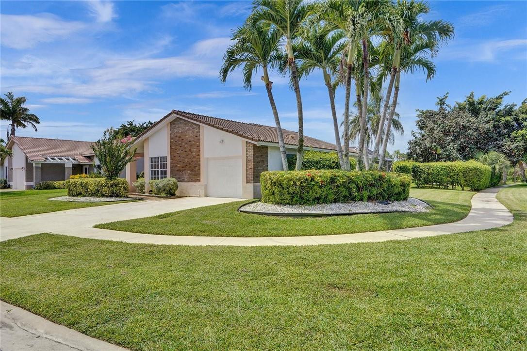 10066 Camelback Lane Boca Raton, FL 33498 - Photo 2 of 34 a view of a white house with a big yard and palm trees