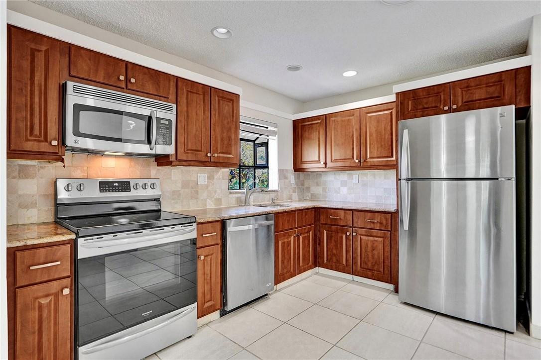 10066 Camelback Lane Boca Raton, FL 33498 - Photo 7 of 34 a kitchen with stainless steel appliances granite countertop a refrigerator stove top oven and microwave