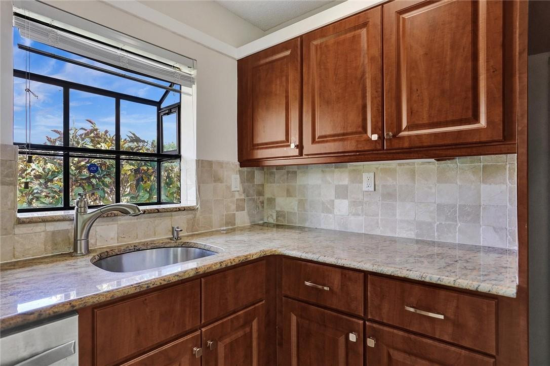 10066 Camelback Lane Boca Raton, FL 33498 - Photo 8 of 34 a kitchen with granite countertop wooden cabinets a sink and dishwasher next to a window