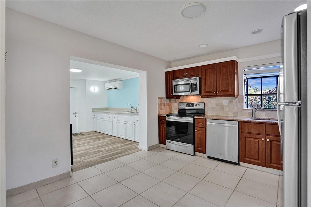 10066 Camelback Lane Boca Raton, FL 33498 - Photo 9 of 34 a kitchen with stainless steel appliances granite countertop a stove top oven a sink and dishwasher