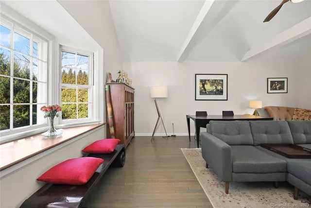 a kitchen with a stove a sink and white cabinets with wooden floors