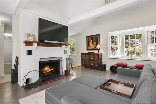 a living room with furniture a flat screen tv and a fireplace