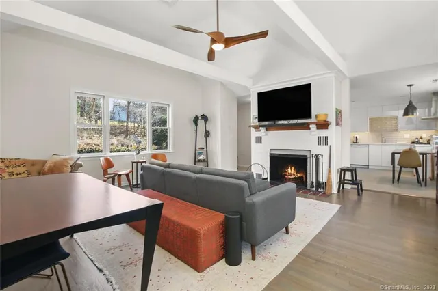 a living room with furniture a large window and a wooden floor