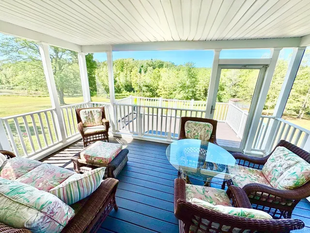 a view of an empty room with wooden floor and furniture