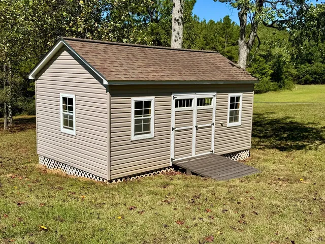 a view of a house with a big yard and large trees