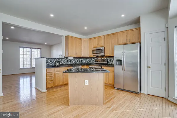 a kitchen with stainless steel appliances granite countertop a refrigerator a sink and a stove