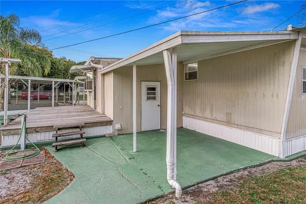 a view of a small house with wooden fence