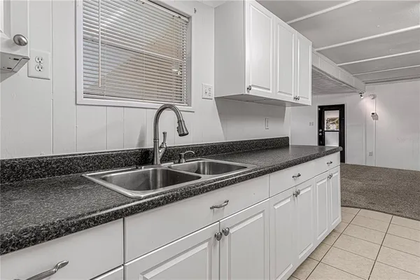 a kitchen with granite countertop a sink and cabinets