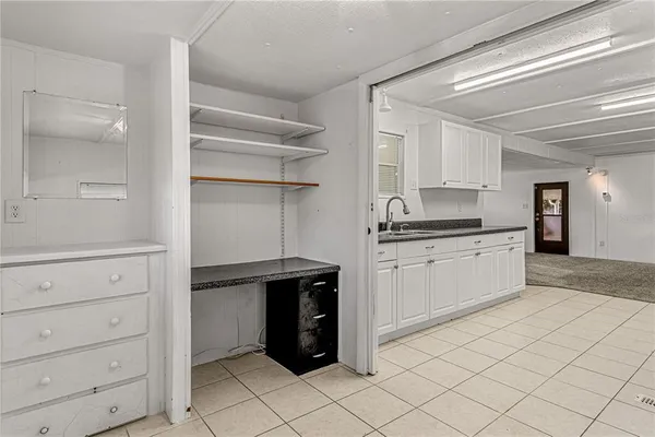 a kitchen with white cabinets and appliances