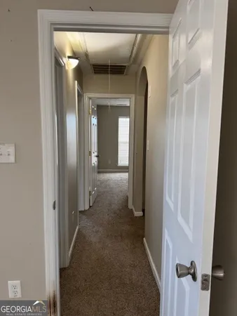 a view of a hallway with wooden floor and closet