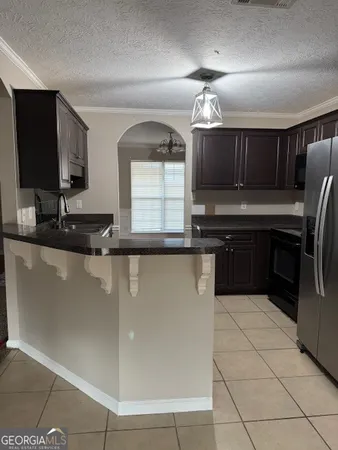 a kitchen with granite countertop a sink and a refrigerator
