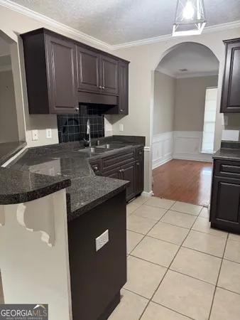 a kitchen with granite countertop a stove a sink and a microwave