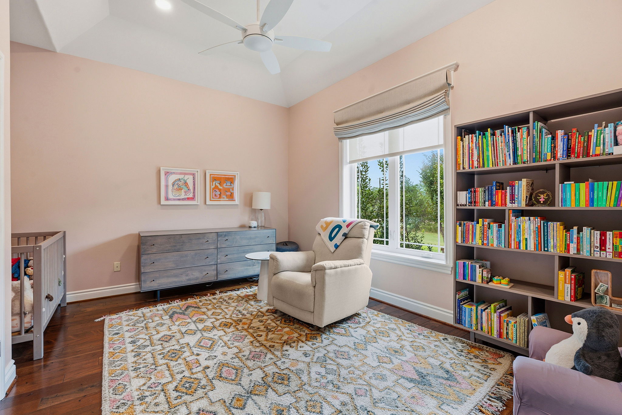 8121 Bluff Trail Austin, TX 78737 - Photo 19 of 40 A comforting nursery features warm hardwood floors, an inviting armchair, and ample natural light.