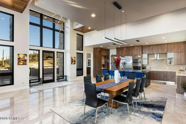 a dining room with stainless steel appliances kitchen island granite countertop a dining table chairs and view living room