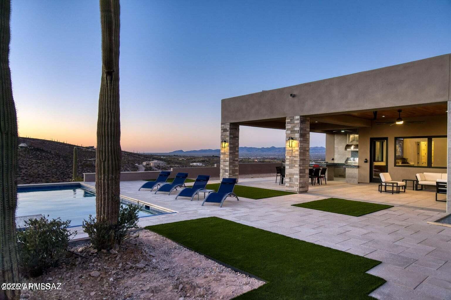 5901 West El Camino Del Cerro Tucson, AZ 85745 - Photo 2 of 50 a view of a patio with a table and chairs under an umbrella