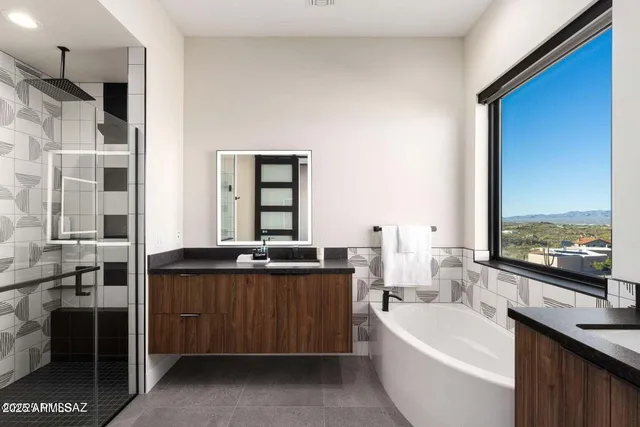 a large bathroom with a double vanity sink a large mirror and a bathtub