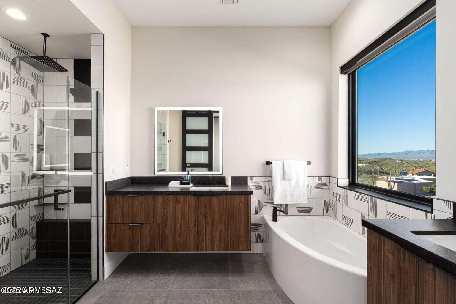 5901 West El Camino Del Cerro Tucson, AZ 85745 - Photo 23 of 50 a large bathroom with a double vanity sink a large mirror and a bathtub