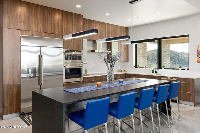 a kitchen with stainless steel appliances granite countertop a sink refrigerator and cabinets