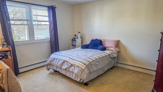 a bed sitting in a bedroom next to a window