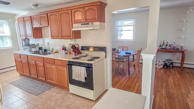 a kitchen with stainless steel appliances granite countertop a stove top oven a sink dishwasher and cabinets with wooden floor