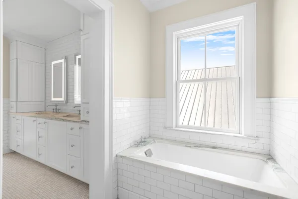 a bathroom with a granite countertop tub sink and mirror