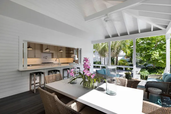 a view of a backyard with couches under an umbrella