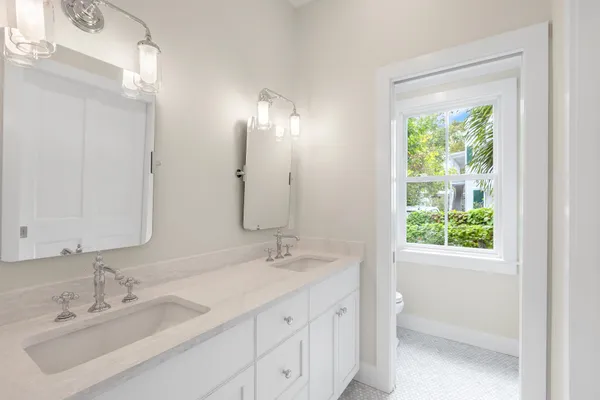 a front view of a house with a yard and potted plants