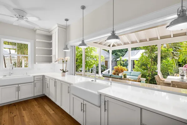 a kitchen with a sink window and chairs