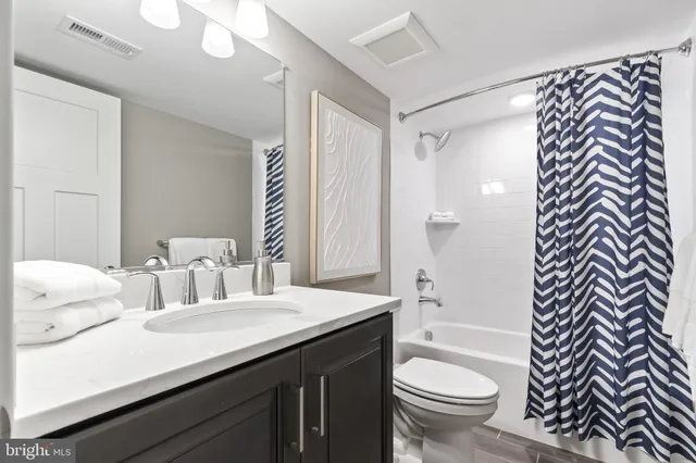 a kitchen with stainless steel appliances kitchen island granite countertop a dining table chairs and a refrigerator