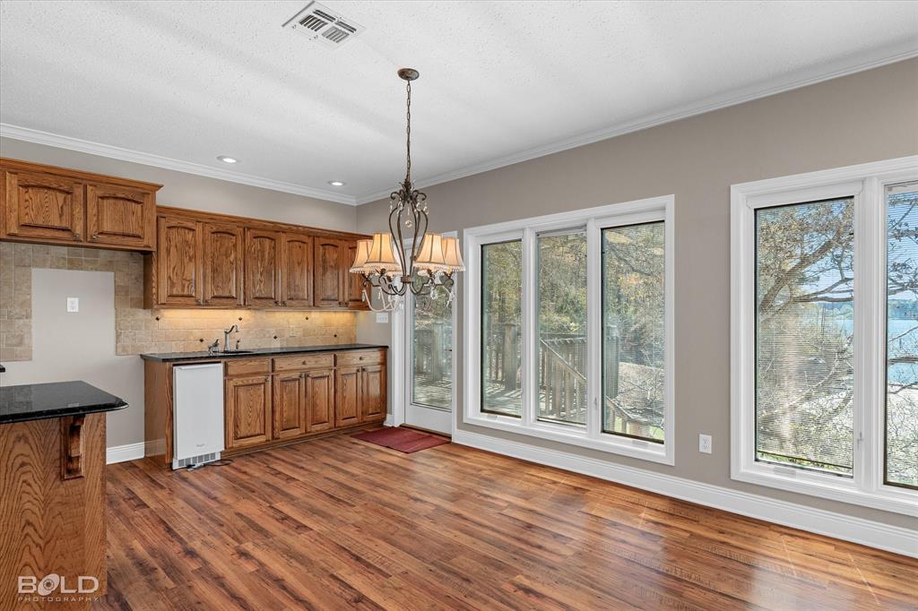 429 Robinson Lane Homer, LA 71040 - Photo 18 of 40 a kitchen with stainless steel appliances granite countertop wooden floors wooden cabinets a sink and a window